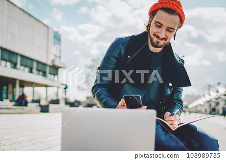 caucasian hipster guy in fashionable outfit chatting with friends 108989785