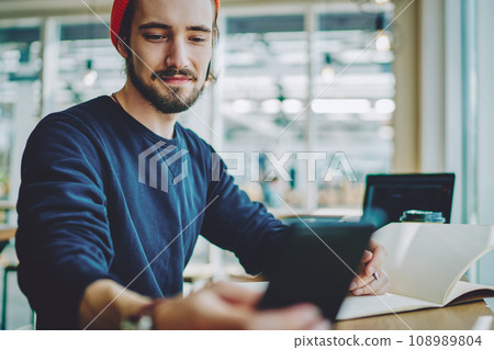 positive hipster guy checking notification on cellular phone 108989804