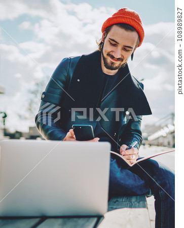 caucasian hipster guy in fashionable outfit chatting with friends caucasian hipster guy in fashionable outfit chatting with friends 108989827