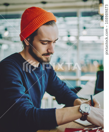 caucasian man in stylish apparel making notes of information in notepad for education 108989873