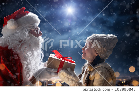 child girl and Santa Claus with gift child girl and Santa Claus with gift 108990845