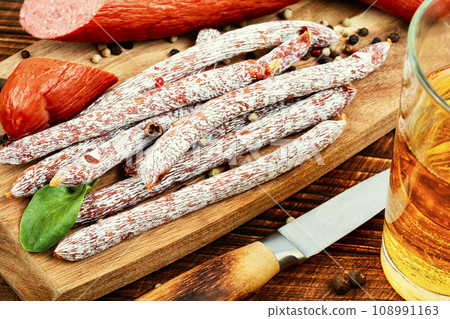 Kabanos, long thin sausages and glass of beer. 108991163