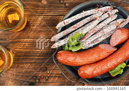 Thin kabanos sausages on wooden background. Thin kabanos sausages on wooden background. 108991165