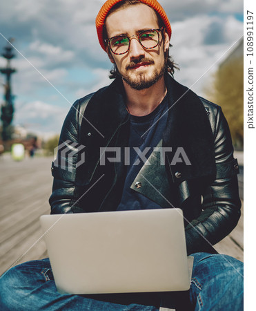 hipster guy with netbook connected to 4G internet looking at camera hipster guy with netbook connected to 4G internet looking at camera 108991197