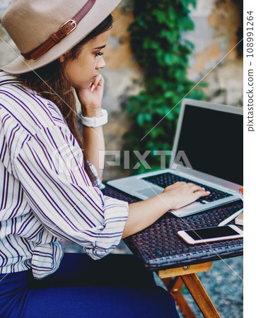 hipster girl read news from social networks and blogging using netbook and wifi connection hipster girl read news from social networks and blogging using netbook and wifi connection 108991264