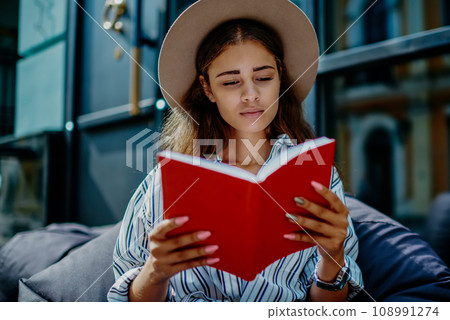 beautiful young woman concentrated on interesting novel bestseller during free time beautiful young woman concentrated on interesting novel bestseller during free time 108991274