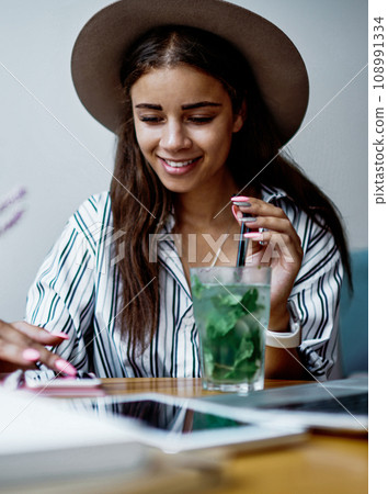 cheerful charming woman freelancer working remotely via gadgets blogging in networks 108991334