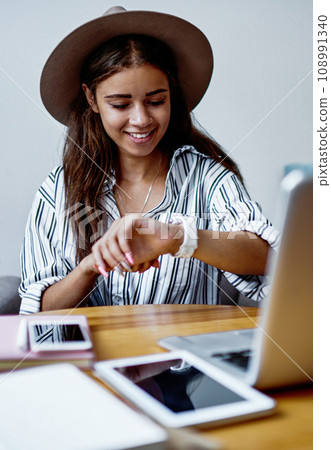 Cheerful caucasian hipster girl working remotely at cafe using modern devices and wireless connection 108991340