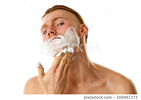 Hygiene treatments. Attractive man applying shaving foam looking at camera against white studio background. Hygiene treatments. Attractive man applying shaving foam looking at camera against white studio background. 108991373