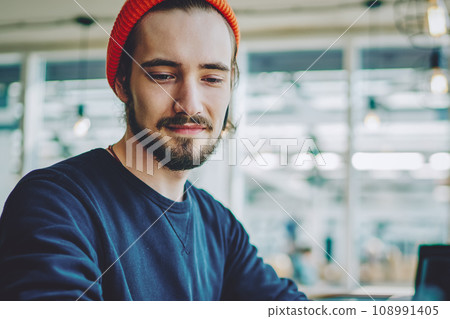positive hipster guy checking notification on cellular phone 108991405
