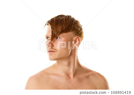 Portrait of naked man, young serious guy with red and wet hair looking away against white studio background. 108991419