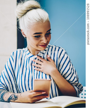Millennial female blogger surprised with sales on website checking notification on smartphone Millennial female blogger surprised with sales on website checking notification on smartphone 108991528