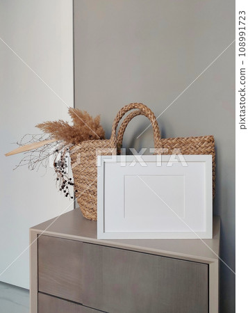 Empty photo frame mockup on wooden table. Elegant workspace, home office concept. Scandinavian minimalistic interior design. Copy space for artwork, photo or print presentation. 108991723