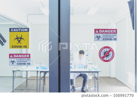 Biohazard disease alert corona outbreak sign on glass wall laboratory science center. Medical care clinic with hazard alert sign. Medical Healthcare concept. 108991770