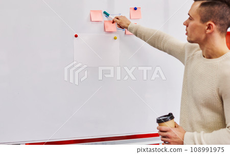 Pensive young man coach holding tasty coffee Pensive young man coach holding tasty coffee 108991975