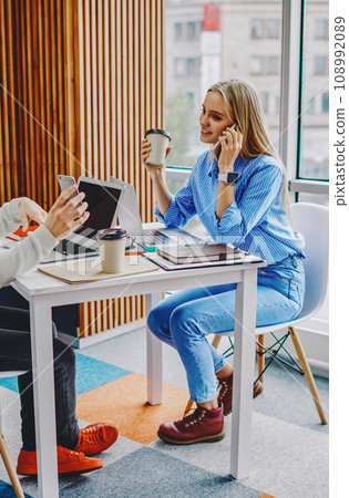 sitting at table with laptop computers in office during break 108992089