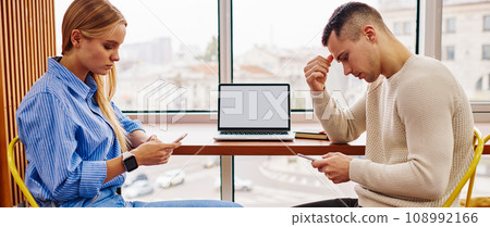 Two antisocial young man and woman from millennial generation ignoring live communication Two antisocial young man and woman from millennial generation ignoring live communication 108992166