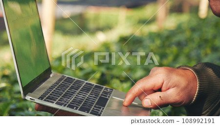Smart farmer using laptop in eco green farm sustainable quality control. Close up Hand typing laptop computer quality control plant tree. Farmer hands using technology in eco Farmland biotechnology 108992191