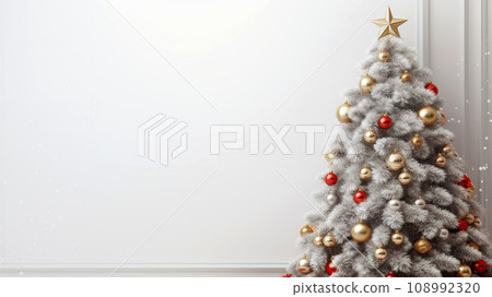 Christmas tree on a white background with copy space. Decorated Christmas tree in a room with a white wall. 108992320