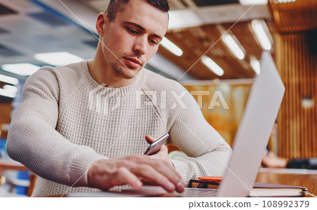 Student updating software on netbook sitting in office Student updating software on netbook sitting in office 108992379