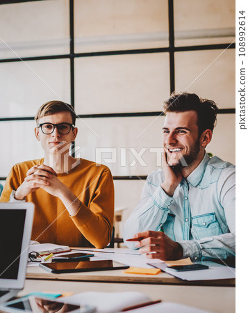 Two successful architects collaborating with each other sitting at desktop Two successful architects collaborating with each other sitting at desktop 108992614