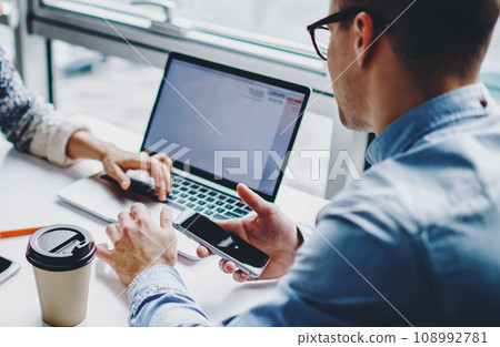 Girlfriend with boyfriend spending leisure together sitting at table with netbook Girlfriend with boyfriend spending leisure together sitting at table with netbook 108992781