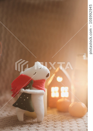 Christmas mood concept. Cozy composition with plaid, toy bear, tangerines and traditional festive decorations Christmas mood concept. Cozy composition with plaid, toy bear, tangerines and traditional festive decorations 108992945