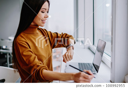 prosperous businesswoman satisfied with modern electronic device on wearable computer on job 108992955