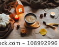 Autumn or winter cozy home interior with a cup, candles, plaid. Hygge home decor.  108992996