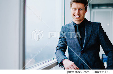 prosperous businessman in formal wear looking at camera satisfied with success in job 108993149