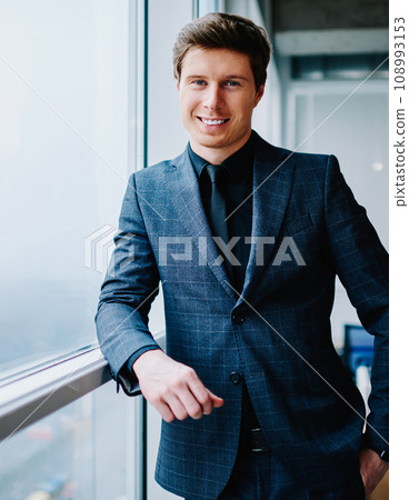 prosperous businessman in formal wear looking at camera satisfied with success in job 108993153