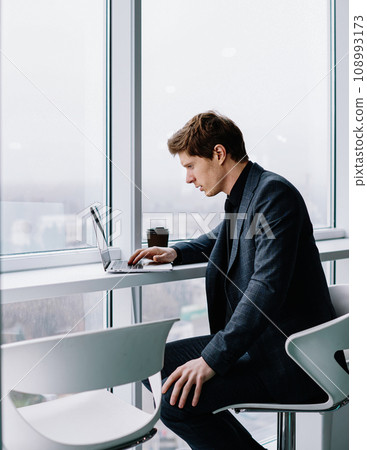 Serious proud ceo reading information from web page browsed on laptop computer during job 108993173