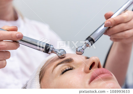 Close up of woman at professional microcurrent procedure. Hardware cosmetology and skin care 108993633