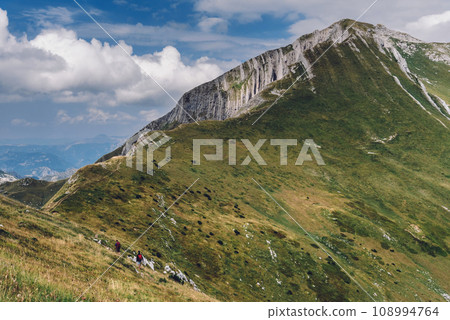 Small People Hiking on Trail High in Mountains 108994764