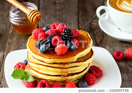Stacked pancakes with fruit toppings 108994796