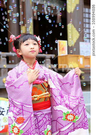 A cute girl wearing a long-sleeved kimono wearing a long-sleeved kimono for a 7-year-old's Shichi-Go-San pilgrimage on location at a shrine. Classic hairstyle. 108994886
