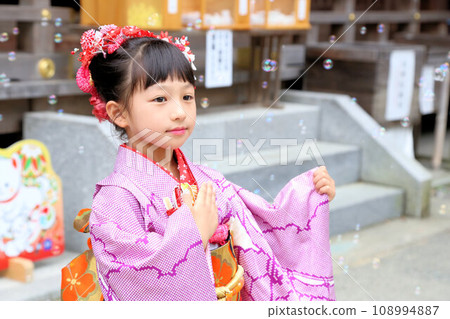 A cute girl wearing a long-sleeved kimono wearing a long-sleeved kimono for a 7-year-old's Shichi-Go-San pilgrimage on location at a shrine. Classic hairstyle. 108994887