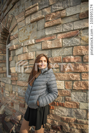 Portrait of diversity young beautiful confident Indian Asian woman in fall season brick building background. Happy and natural smiling female. Generation z and gen z youth concept 108995174