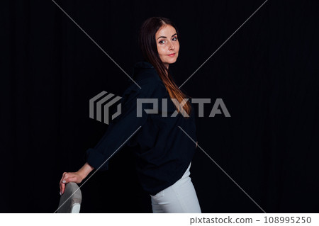 Portrait of beautiful brunette woman in white pants and black shirt 108995250