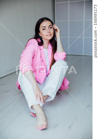 Beautiful brunette woman in white suit and pink jacket 108995273