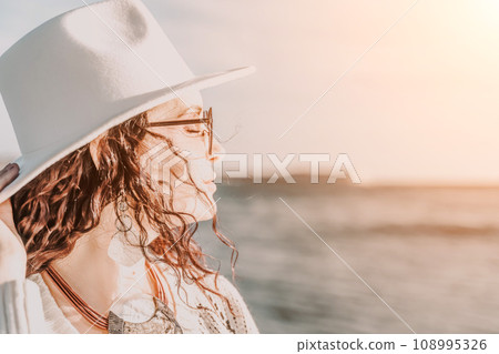 Portrait of a curly haired woman in a white hat and glasses on t 108995326
