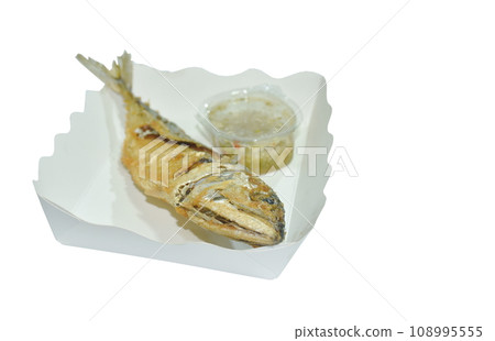 crispy fried fresh mackerel fish arranging on paper package dipping spicy chili sauce in white background crispy fried fresh mackerel fish arranging on paper package dipping spicy chili sauce in white background 108995555