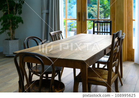 A space with a large wooden dining table 108995625