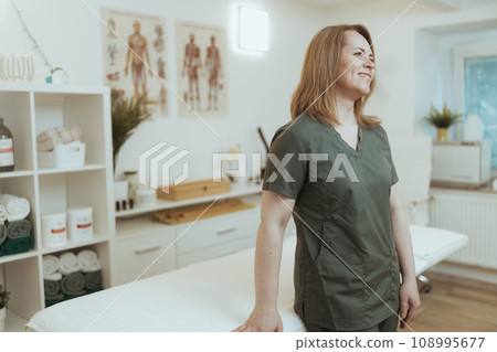 smiling massage therapist woman in massage cabinet 108995677