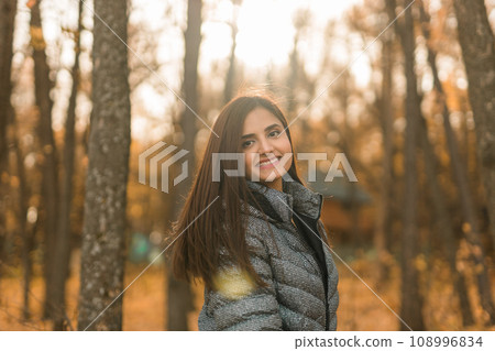 Close up portrait of pretty indian young woman enjoying warm autumn sunny day vacation outdoors copy space mockup. Generation z and gen z concept. Fall Season 108996834