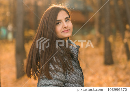 Close up portrait of pretty indian young woman enjoying warm autumn sunny day vacation outdoors copy space mockup. Generation z and gen z concept. Fall Season 108996870