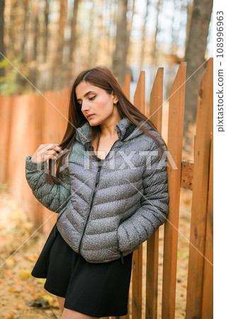 Close up portrait of pretty indian young woman enjoying warm autumn sunny day vacation outdoors. Generation z and gen z concept. Fall Season 108996963