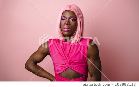 Muscular black transgender model wearing pink dress 108998138