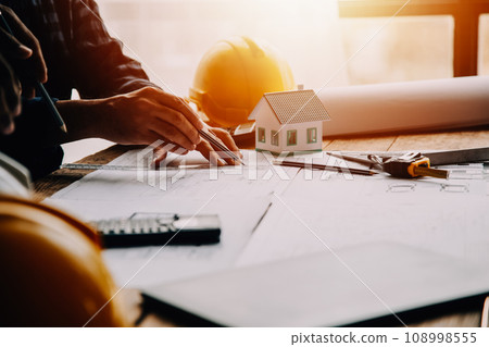 Construction and structure concept of Engineer or architect meeting for project working with partner and engineering tools on model building and blueprint in working site, contract for both companies. Construction and structure concept of Engineer or architect meeting for project working with partner and engineering tools on model building and blueprint in working site, contract for both companies. 108998555