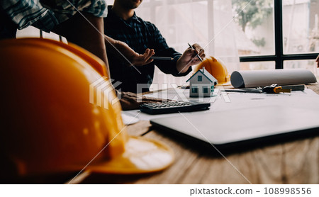 Construction and structure concept of Engineer or architect meeting for project working with partner and engineering tools on model building and blueprint in working site, contract for both companies. 108998556